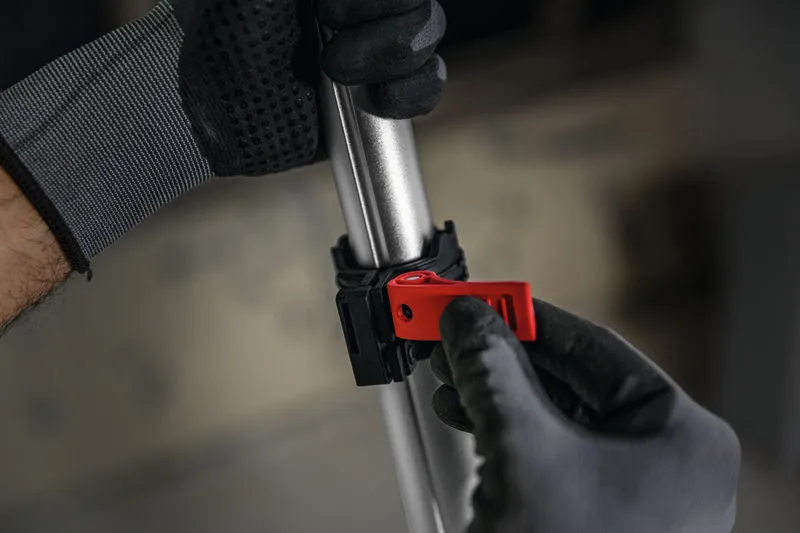 一名佩戴安全装备的人员正在调整金属杆上的红色夹子。