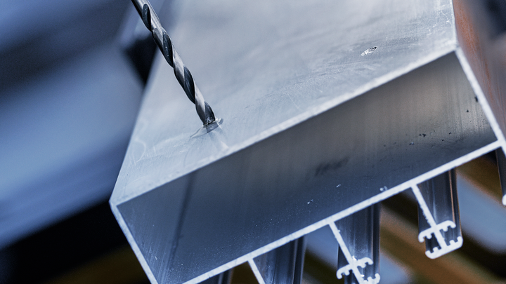 钻头正在厚金属梁上钻孔。