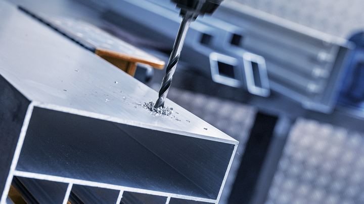 用钻头在金属梁上钻孔。