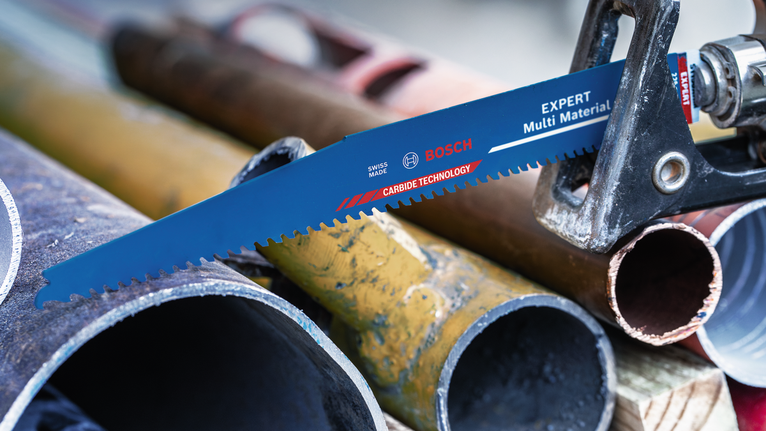 在车间环境中，锯片正在切割各种金属管。