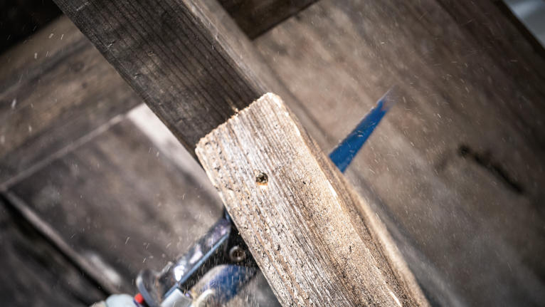 电动工具切割木板，木屑飞溅。