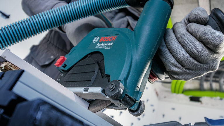 佩戴安全装备的人员使用圆锯切割材料。