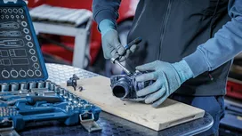 佩戴安全装备的人员使用棘轮工具修理机械部件。