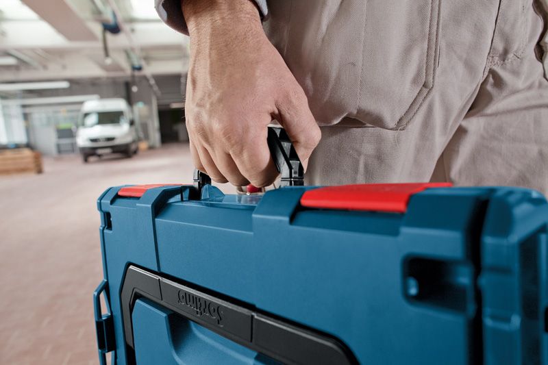 车间内一名人员携带蓝色工具箱。.